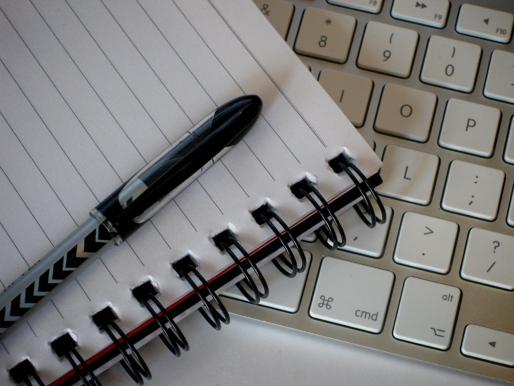 Open notebook, pen, and keyboard close-up