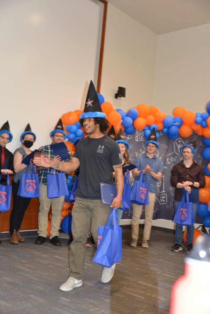 Photo of Robel Clifton walking to receive his award, with his classmates in the background