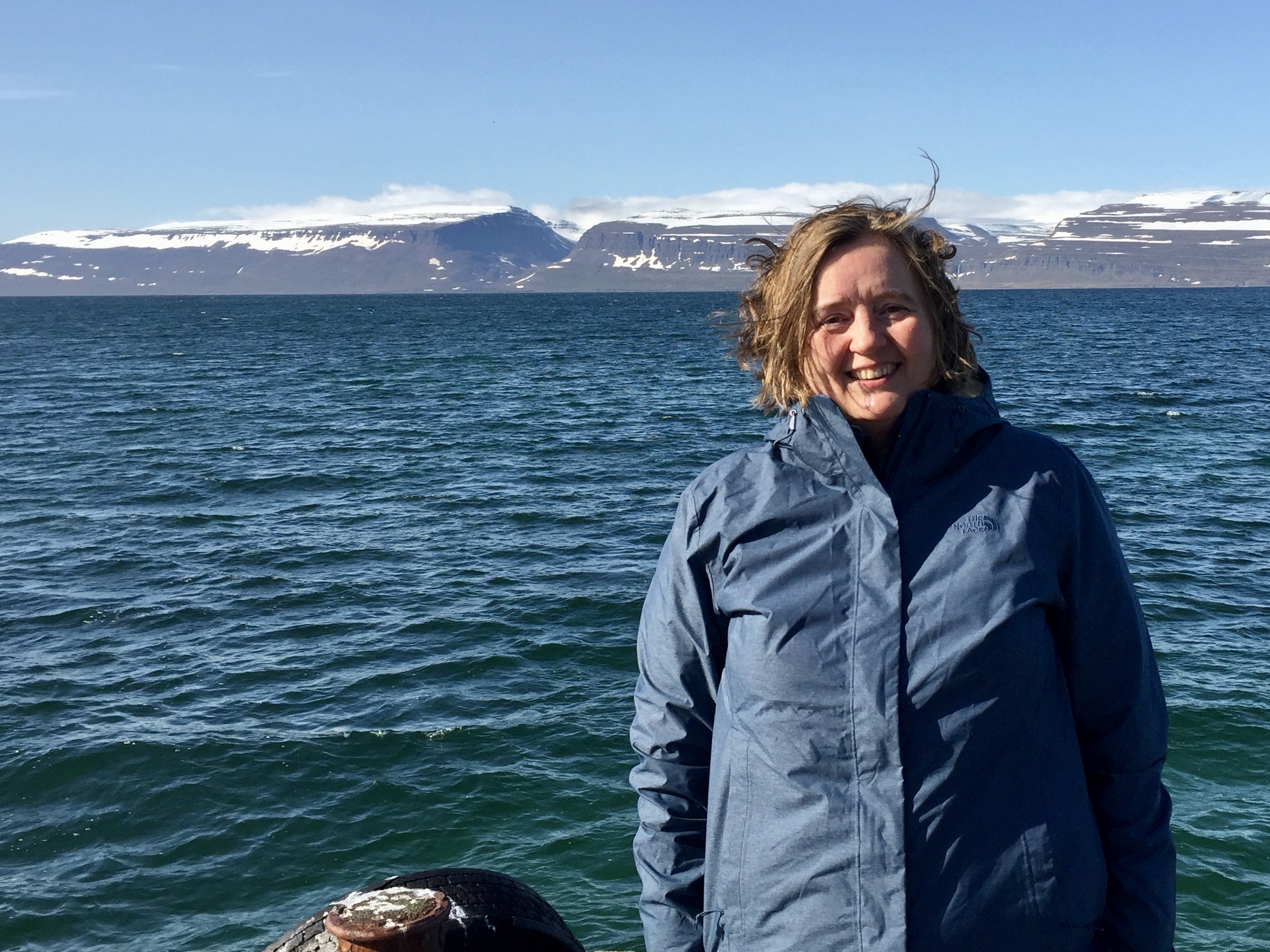 Joanne Klein portrait with mountains and a body of water in the background