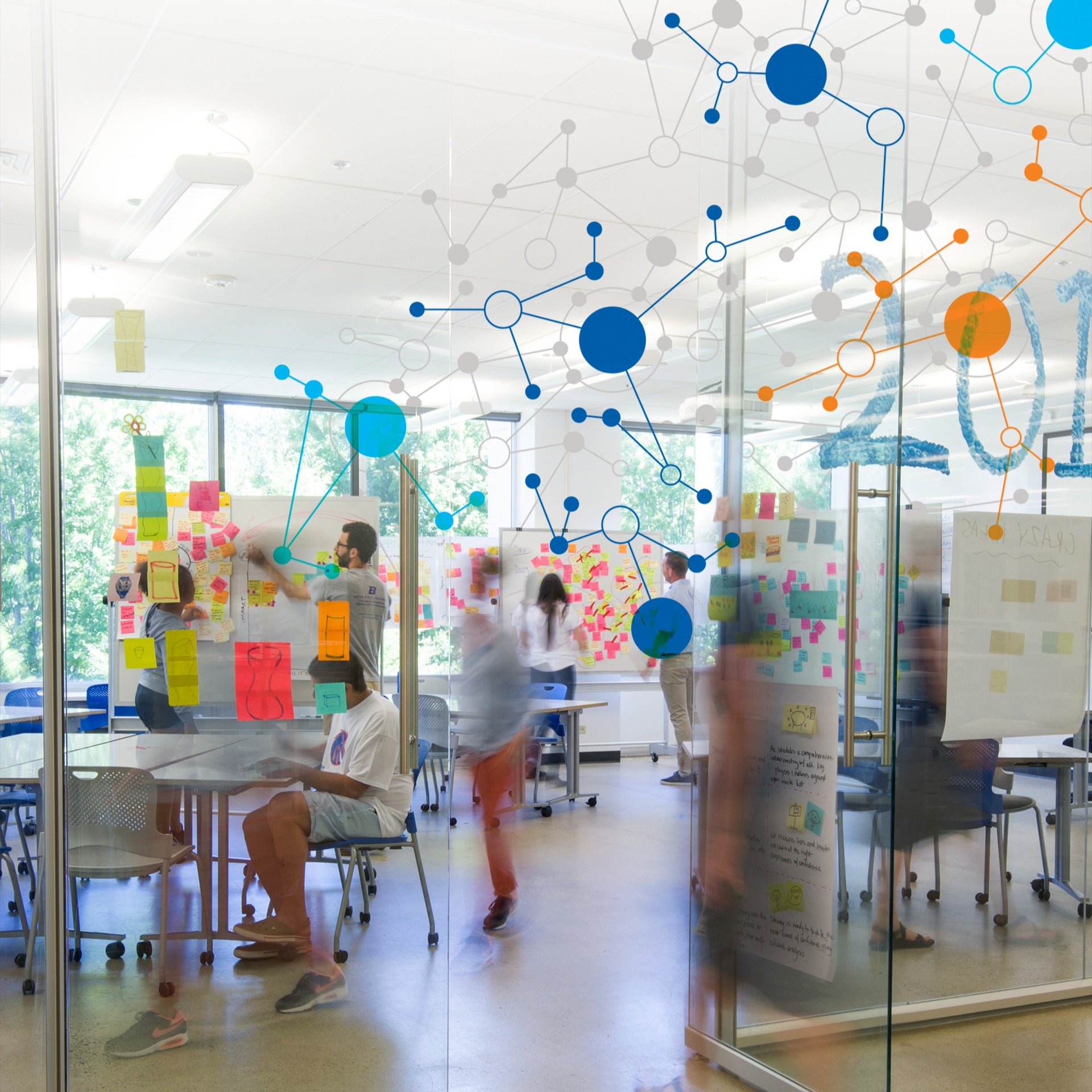 Group collaborating in a glass-walled room with vibrant sticky notes, diagrams, and molecular structure designs.