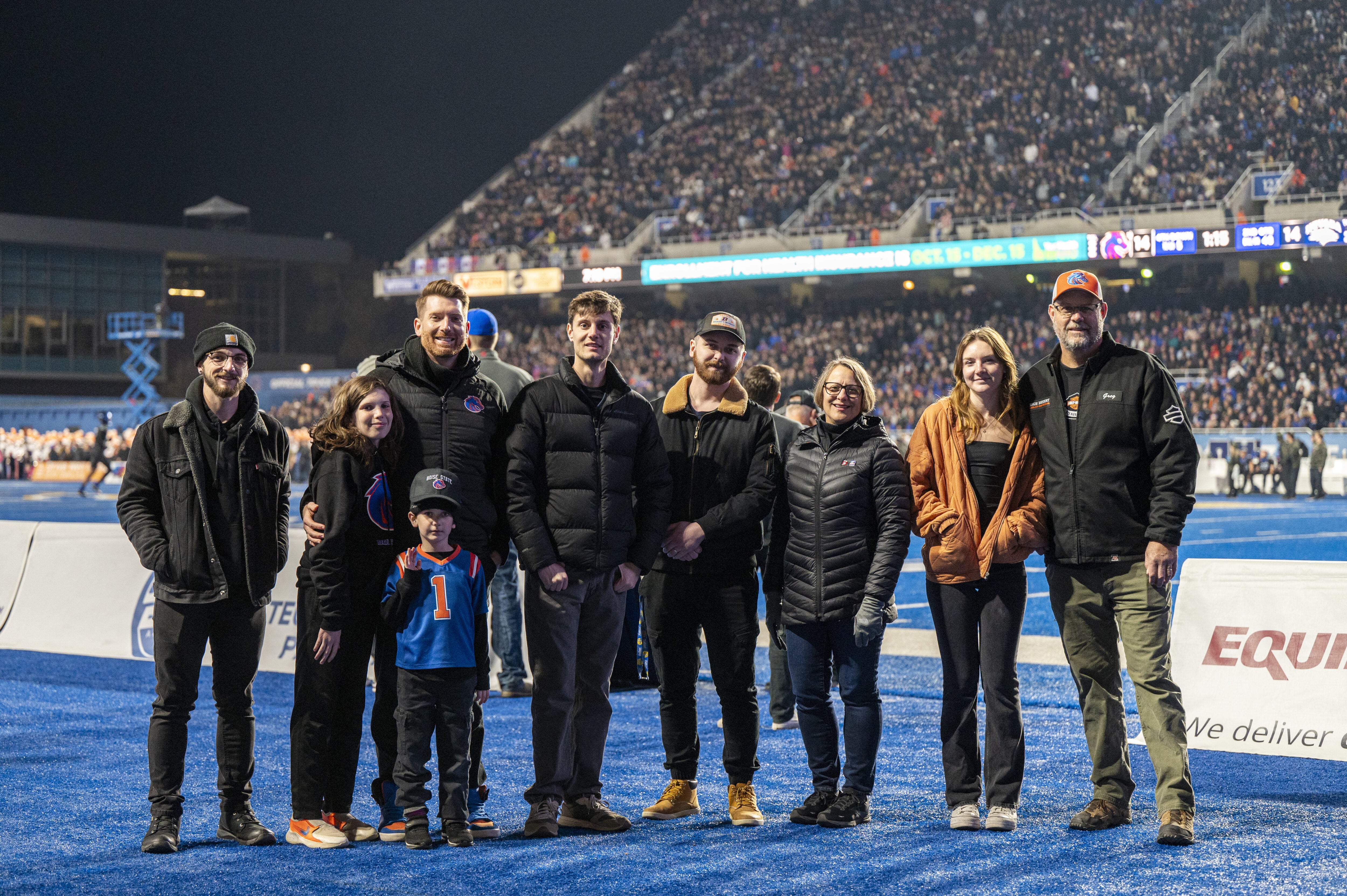Persons pose on a football field