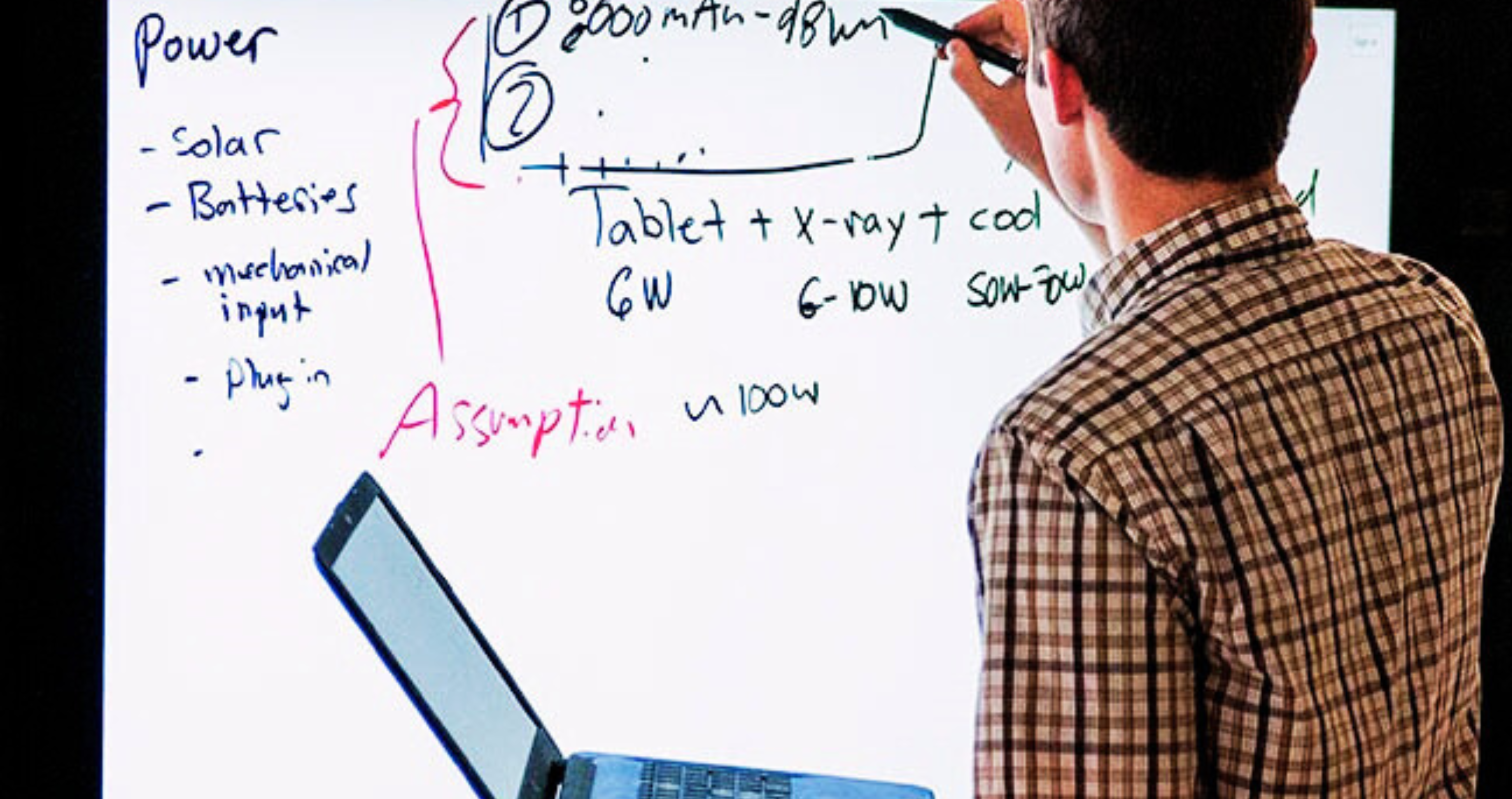 faculty writing equations on a white board