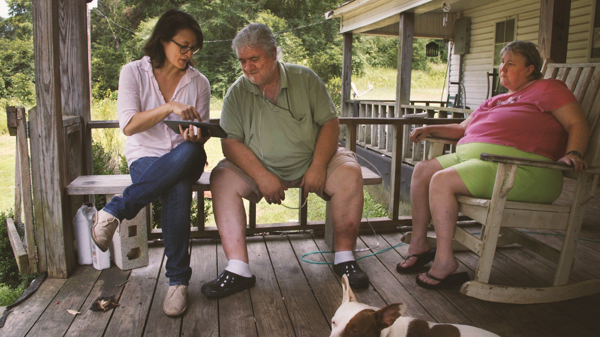 Three people sitting on a porch