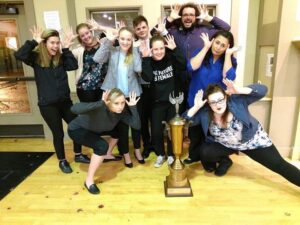 Social Work students pose around a trophy
